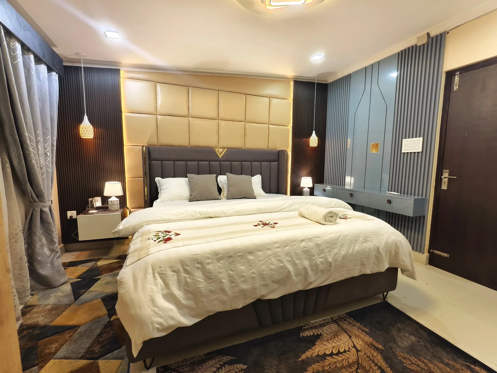Bedroom three at Omnia Luxe Villa, padded headboard with blue accent wall